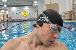 Nadador usando audífonos acuáticos POLVCDG X7 en piscina